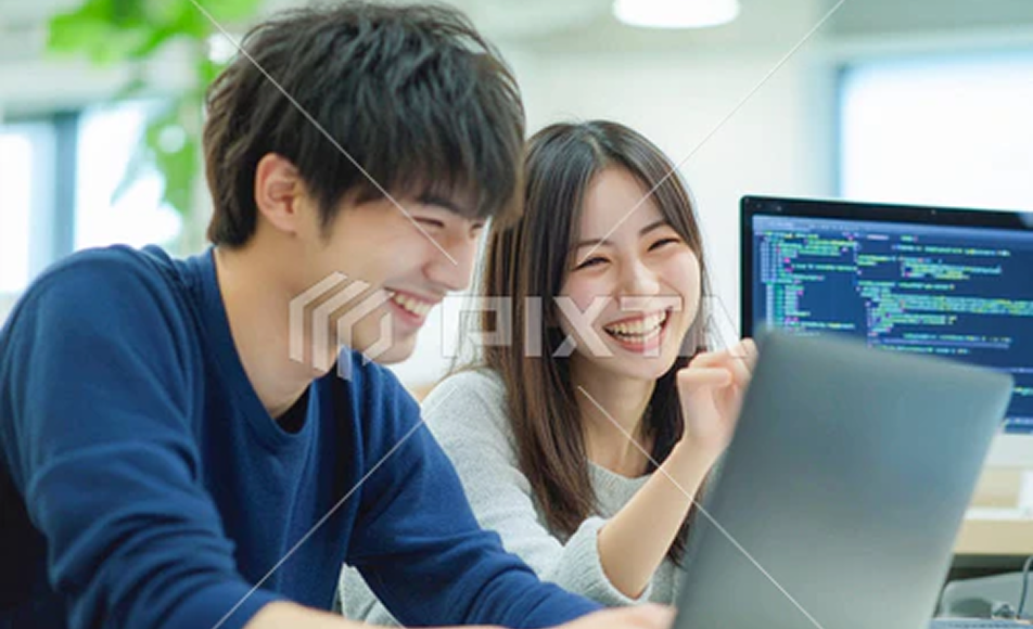 PCを見ながら笑顔で開発するメンバー